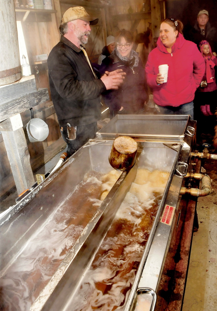BOILING: Steve Lemieux explains how to make maple syrup as his second batch of the season boils in his sap house in Fairfield Center during Maine Maple Sunday on Sunday. Listening to Lemieux is Lori Fortier, left, and Shonna Marchetti.