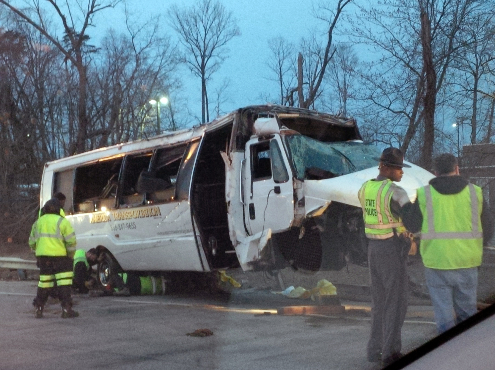 Police investigate the scene of a bus accident on Interstate 95, early Sunday in Fairfax County, Va. The shuttle bus struck a guardrail and overturned before dawn Sunday just south of the nation’s capital, leaving at least one person dead and sending 16 others to the hospital, Virginia State Police said.