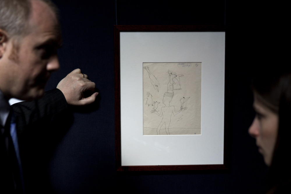 A Sotheby’s employee, left, speaks to a journalist beside an untitled illustration of a boy with six birds by the late Beatles members John Lennon at the auction house’s premises in central London. The ink drawing in black with editorial notes is estimated to fetch between $19,795 to $24,744 in a June 4 New York sale of Lennon autograph drawings and manuscripts produced for his books “In His Own Write” and “A Spaniard in the Works”.