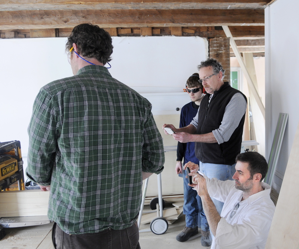 FINE HOMES: Justin Fink, left, a Fine Homebuilding magazine editor, planes a board as video producer Colin Russell, bottom right, director of photography Brian McAward and intern Matt Plourde shoot a segment at the Palermo home that builder Mike Maines is renovating.