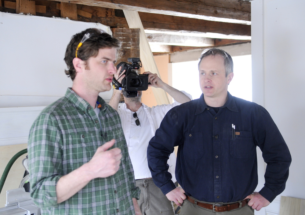 FINE HOMES: Justin Fink, left, a Fine Homebuilding magazine editor, speaks Wednesday with carpenter Mike Maines, right, as Fine Homebuilding producer Colin Russell records them at the 19th century home in Palermo that Maines is renovating. Erskine Academy senior Matt Plourde is interning with the builder and journalists.