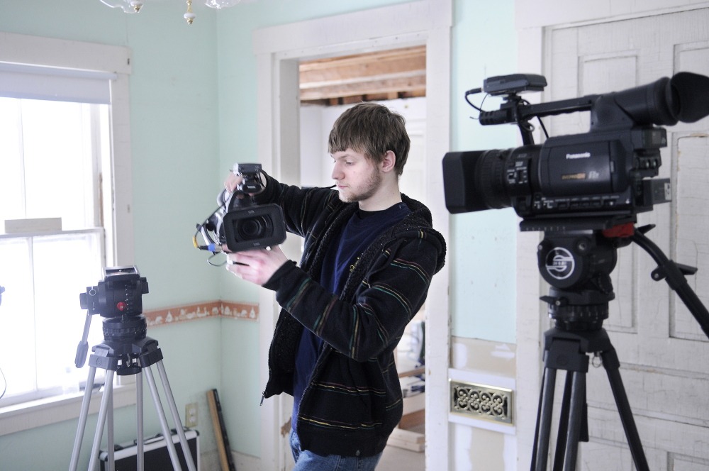 FINE HOMES: Erskine Academy senior Matt Plourde sets up video cameras Wednesday for a piece that Fine Homebuilding magazine is recording at a home in Palermo. A crew of three from the Connecticut magazine is working for a week at the 19th century cape that carpenter Mike Maines is renovating. Plourde, of Winslow, is assisting the crew.