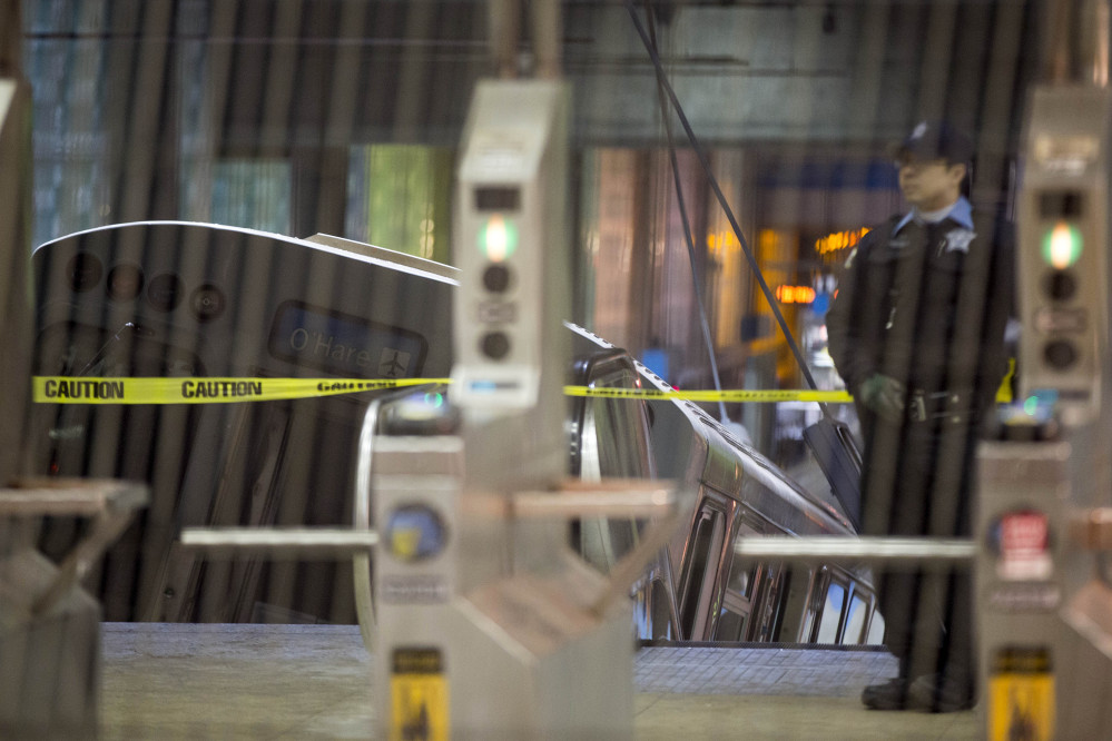 A police officer stands near a Chicago Transit Authority train car that derailed at the O’Hare Airport station early Monday.