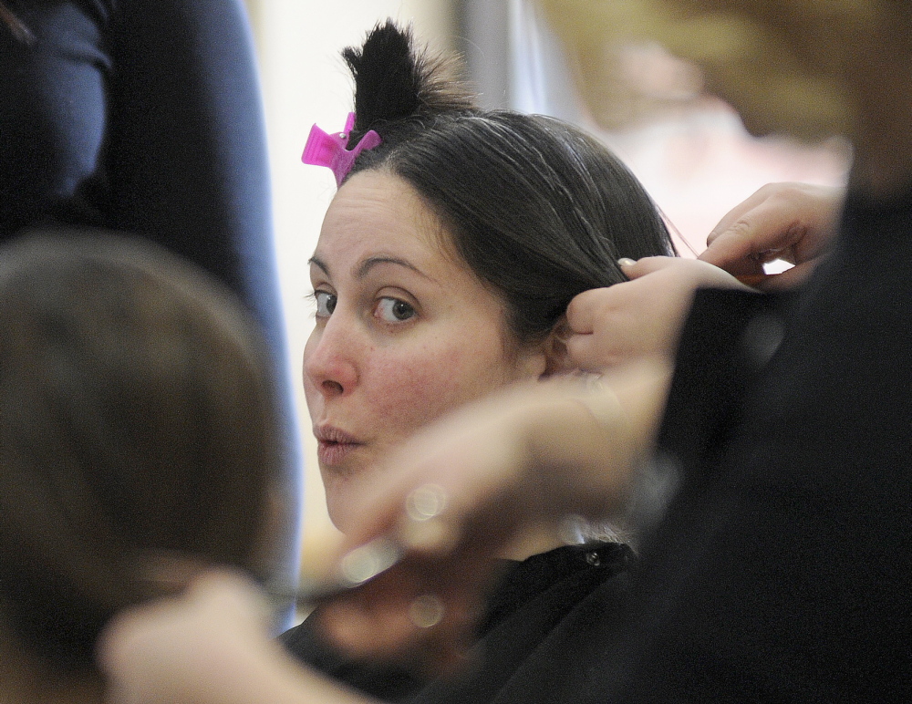 GIVING BACK: Renee Grant, center, of Gardiner gets a new look Monday after donating her hair to Locks of Love, a charity that gives hair to children, during an event at the University of Maine at Augusta. Students from Capilo Institute of Augusta donated their services to cut the hair.