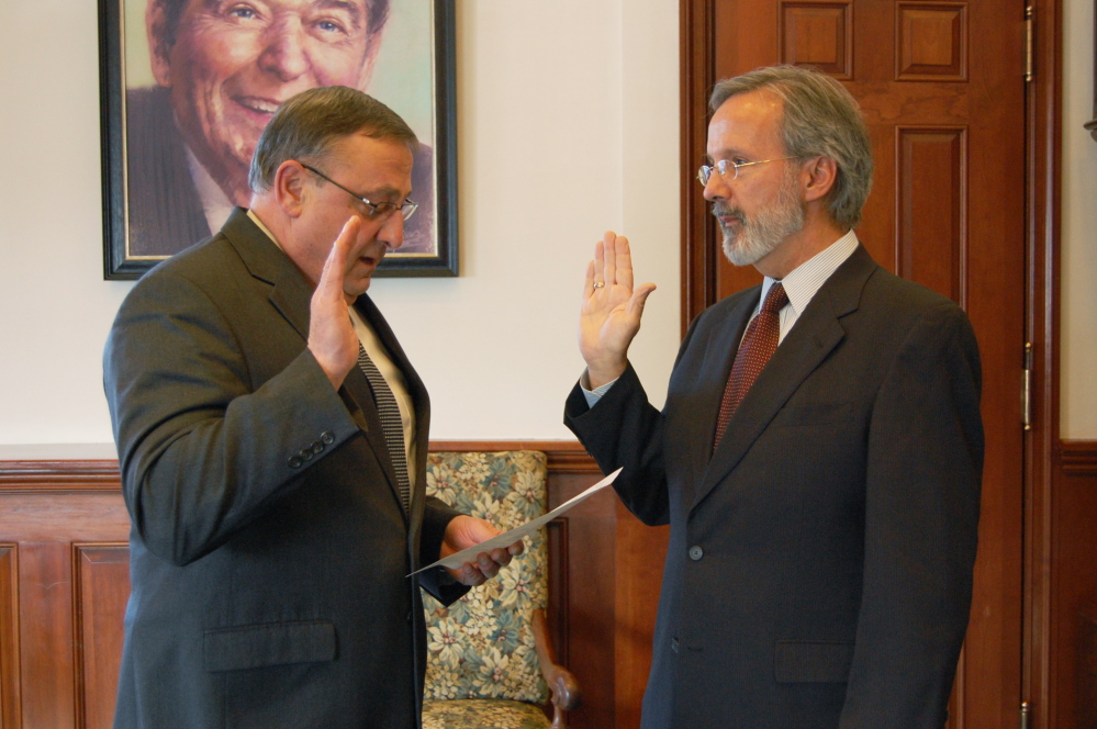 Paul H. Sighinolfi, right, is sworn in as workers’ comp board executive director by Gov. Paul LePage, who ousted the previous director in 2011 after three months in office.