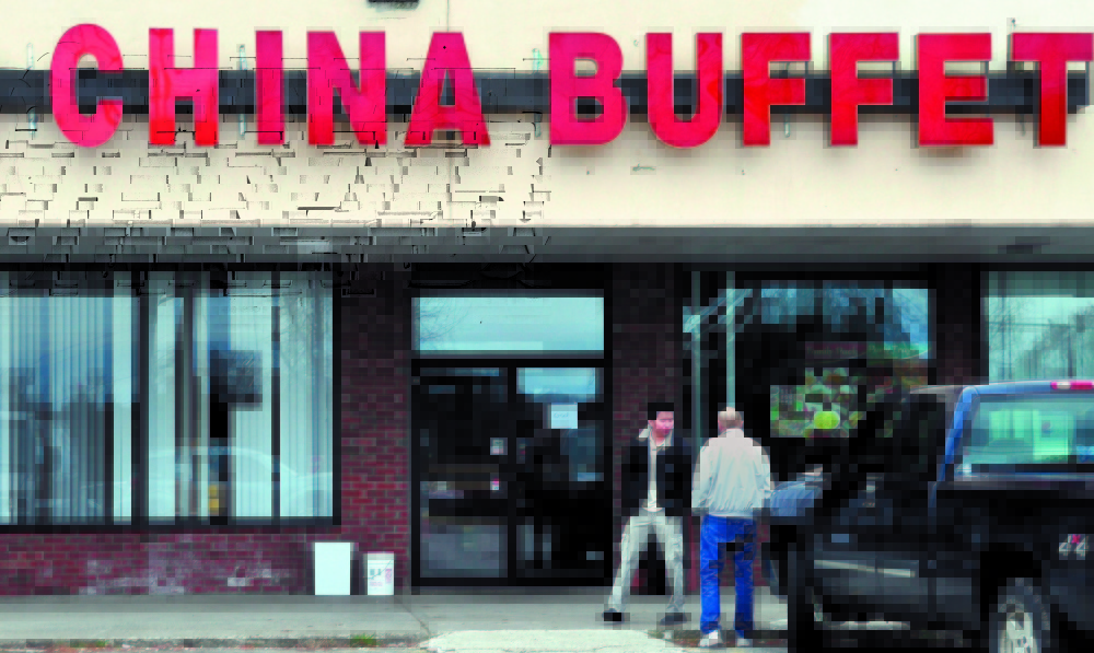 FEDERAL CHARGES: An employee, left, at the Super China Buffet restaurant on Kennedy Memorial Drive in Waterville speaks with another man shortly after U.S. Immigration and Customs Enforcement agents raided the restaurant in 2011. The former manager, Mei Juan Zhang, 31, of Fairfield, was sentenced to 14 months in prision and three years of supervised release on a number of charges related to the raid.