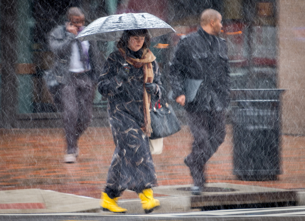 Early-morning commuters walk through snow flurries in Washington on Tuesday.