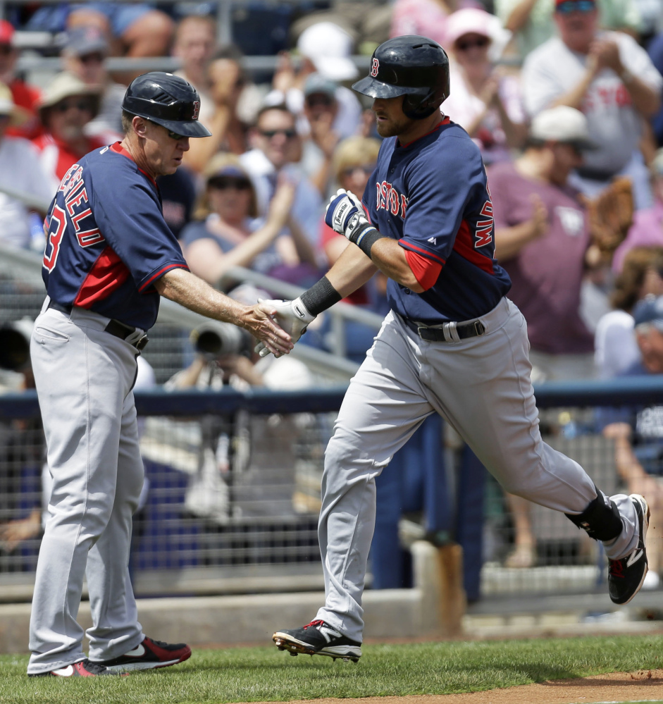 Boston Red Sox’s Will Middlebrooks, right, is greeted by Boston Red Sox third base coach Brian Butterfield as he rounds third base on his solo home run in the third inning of an exhibition baseball game against the Tampa Bay Rays in Port Charlotte, Fla., Tuesday, March 25, 2014. The Red Sox won 4-2.