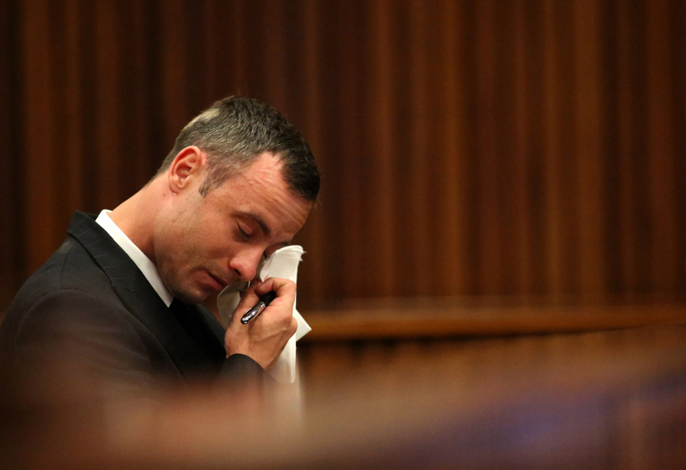 Oscar Pistorius reacts in the dock during cross questioning about mobile phone text messages between him and Reeva Steenkamp in court in Pretoria, South Africa, Tuesday.