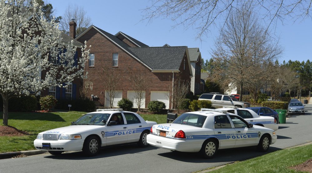 Charlotte-Mecklenburg Police Department cars sit outside Charlotte Mayor Patrick Cannon’s home as federal agents search the house on Wednesday.