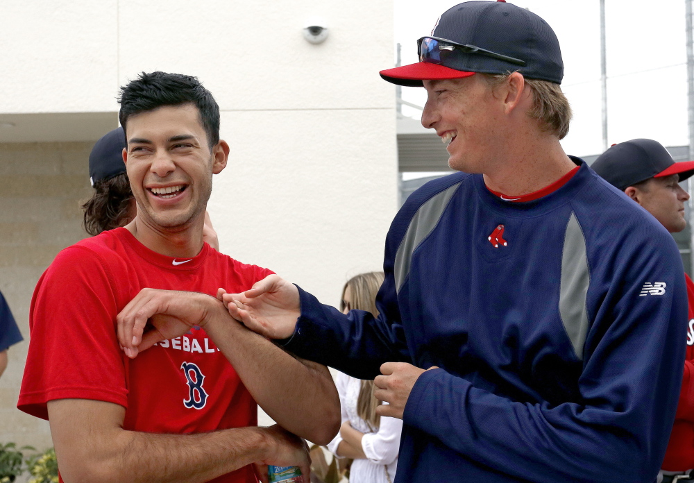 TOGETHER FOR NOW: Noe Ramirez, left, and Henry Owens, right, both pitchers in the Boston Red Sox organization, joke with each other while watching a minor league spring training game last week in Fort Myers, Fla. Ramirez and Owens are close friends, and both grew up in Southern California.