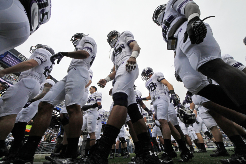 The Northwestern football team heads to the locker room after warming up before an NCAA game against Penn State in State College, Pa., in this Oct. 6, 2012, photo. A federal agency ruled Wednesday that the Northwestern football team can bargain with the school as employees represented by a union.