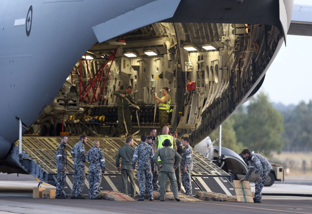 Ground crew prepare to unload a Sea Hawk helicopter from a Royal Australia Air Force C-17 after it landed at RAAF Base Pearce to help with the search for the missing Malaysia Airlines Flight MH370 in Perth, Australia, on Friday.