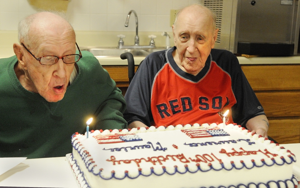 TWIN CENTENARIANS: Lawrence Binette, left, blows out his candle with his twin brother, Maurice Binette, on Thursday at an early 100th birthday party at the Maine Veterans’ Home in Augusta.