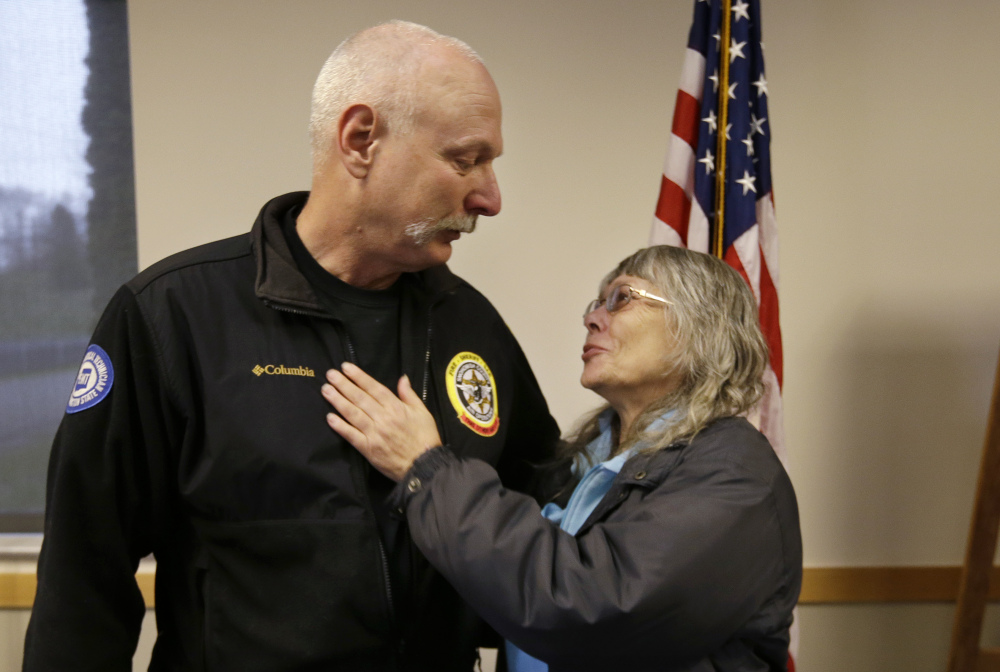 Robin Youngblood embraces Snohomish County helicopter crew chief Randy Fay, who helped rescue her from the deadly mudslide that moved her house a quarter-mile.