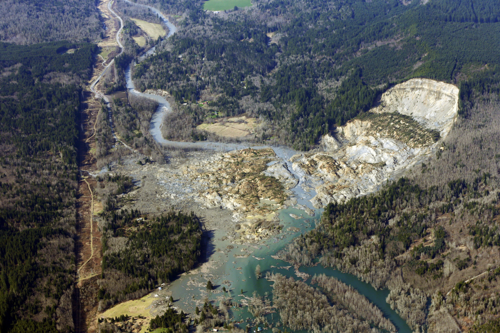 This aerial photo shows the massive mudslide that killed at least eight people Saturday and left dozens missing, near Arlington, Wash.