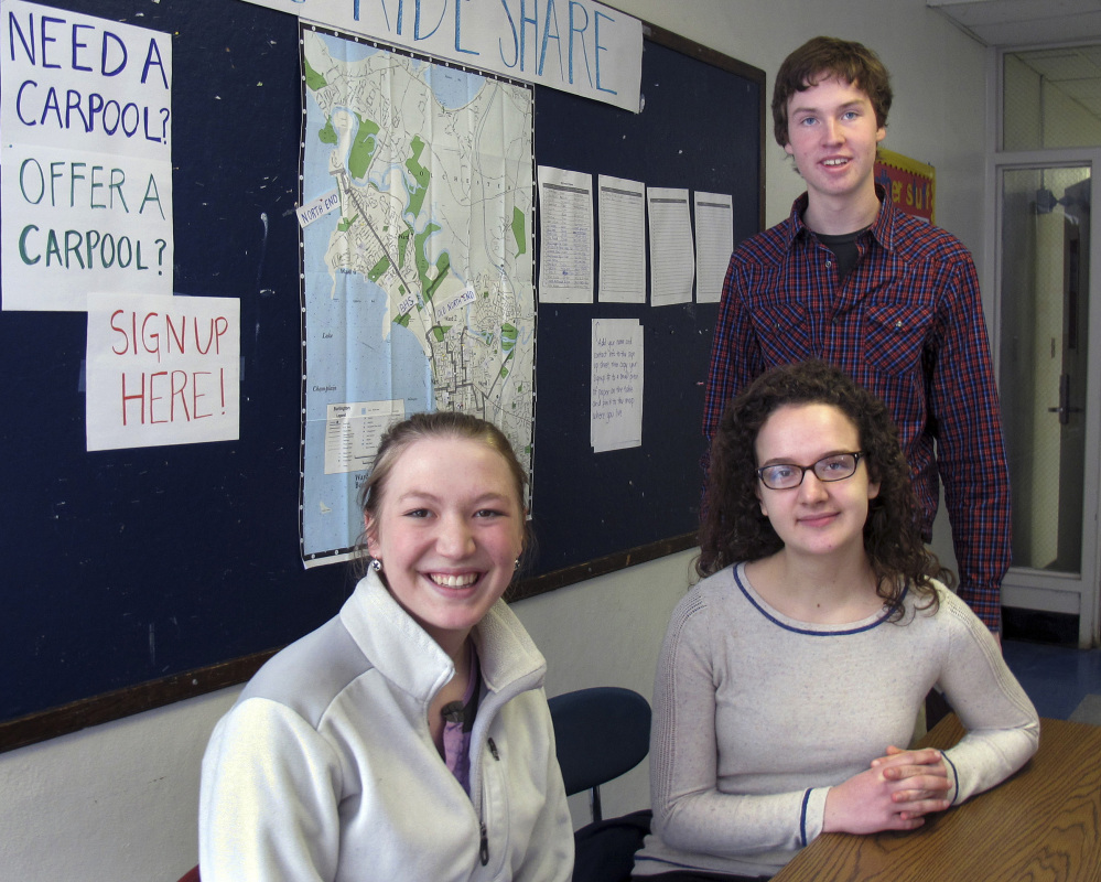 Burlington High School seniors Abby Massell, left, Sabine Rogers and Henry Prine pose in front of a map they helped create to assist students to find rides to and from school as a strike by local bus drivers continued into its second week.