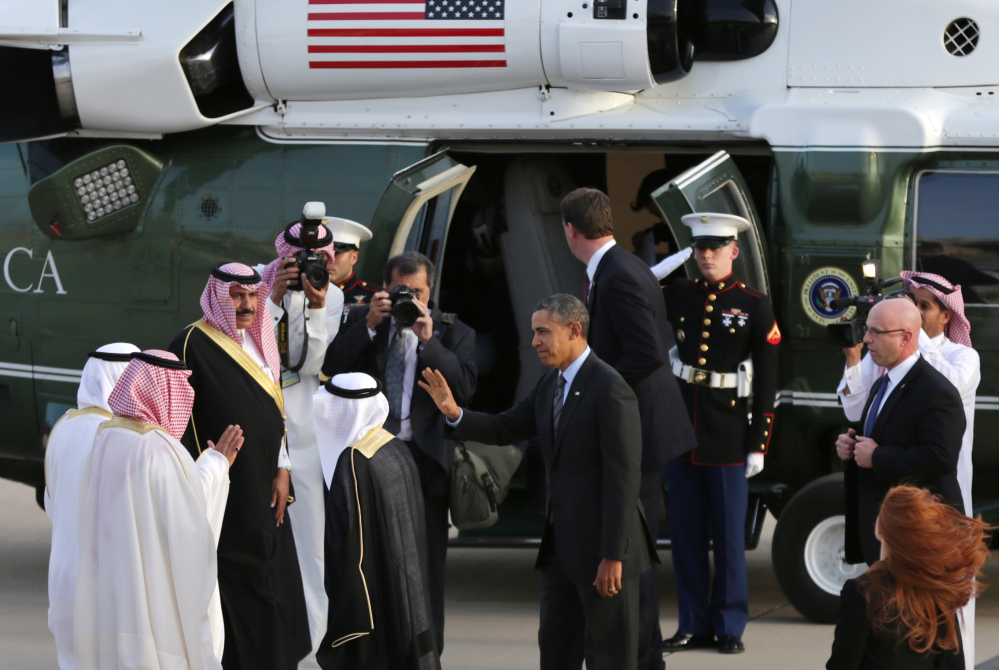 President Barack Obama waves to Governor of Riyadh Prince Khalid Bandar bin Abdul-Aziz Al-Saud and other Saudi officials next to his helicopter in Riyadh, Saudi Arabia, as the president prepares to travel to the Saudi king’s desert compound Friday.