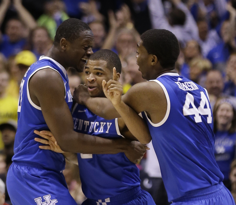 Kentucky’s Aaron Harrison is congratulated by teammates Julius Randle and Dakari Johnson (44) after making a three-point basket in the final seconds of the second half of an NCAA Midwest Regional final college basketball tournament game against Michigan on Sunday in Indianapolis.