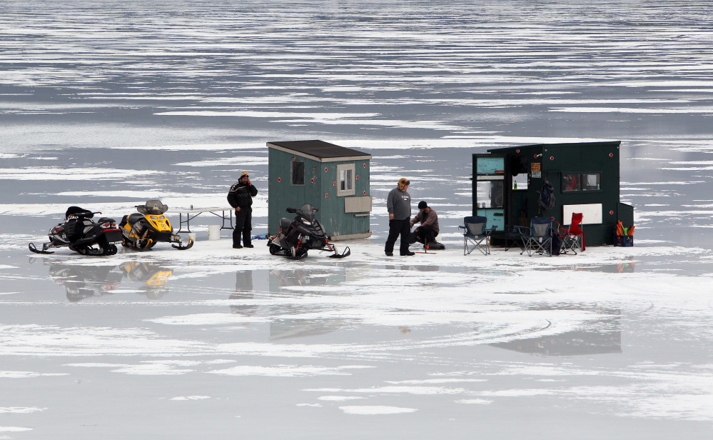 Ice fishermen are seen in Alton Bay on New Hampshire’s Lake Winnipesaukee on Friday in Alton, N.H. Ice on the lake is still more than 2 feet thick in spots as the open-water season begins Tuesday.