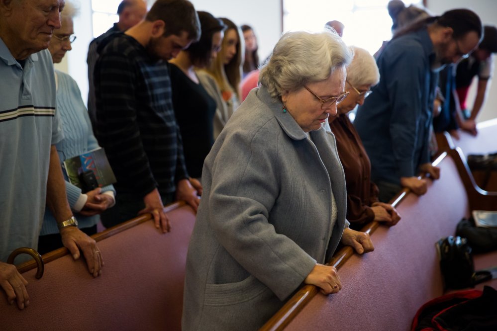 Rose Fagerberg, center, bows her head in prayer during Sunday church service at the Glad Tidings Assembly of God, in Darrington, Wash.