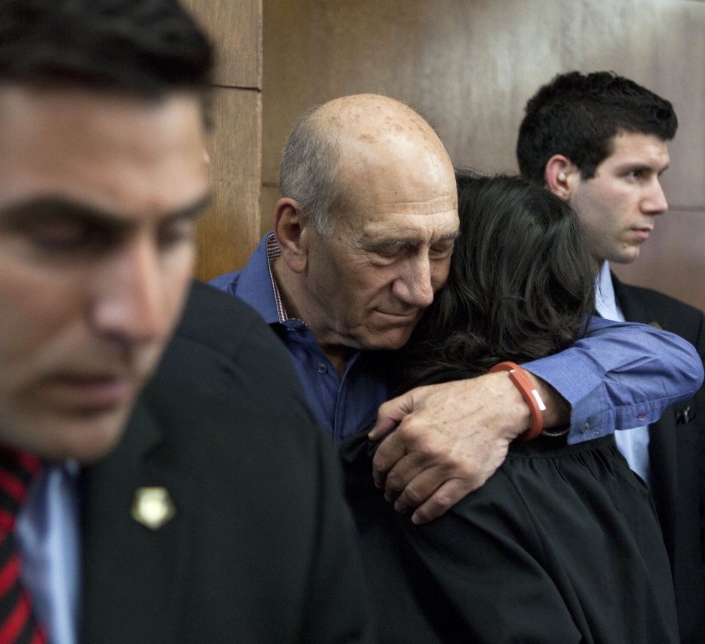 Former Israeli Prime Minister Ehud Olmert hugs a friend before a hearing at Tel Aviv’s District Court on Monday. Olmert was convicted in a high-profile bribery case.