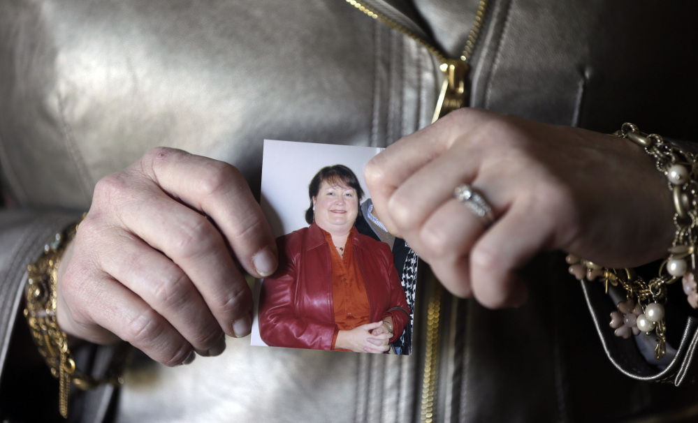 Heather Britton holds a photo of herself taken before her weight-loss surgery, at her home in Bay Village, Ohio.