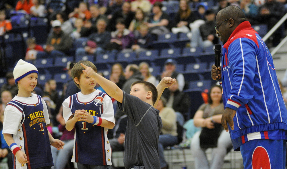 Staff photo by Andy Molloy Nathan Love, center, 10, of Belgrade throws down the love Monday night during a Harlem Globetrotters match in Augusta.