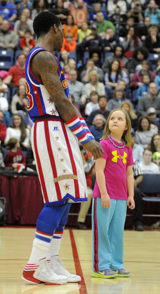Staff photo by Andy Molloy Suzie Webster, 7, of Winthrop teaches Harlem Globetrotter Bull Bullard a move during a match Monday in Augusta.