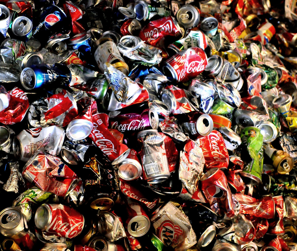 Empty and crushed soda cans build up on a conveyer belt near the end of the line at Tennis Sanitation in Saint Paul Park, Minn. Americans cut back on soda again in 2013, extending a trend that began nearly a decade ago.