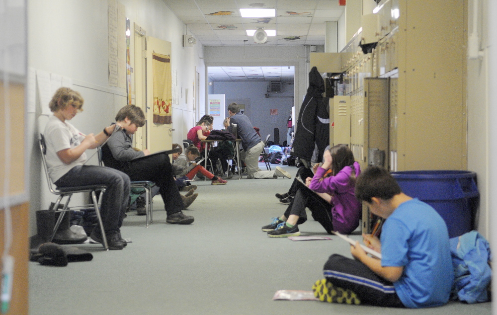 Space Issues: Students work in a hallway Thursday at the Monmouth Middle School. The school has been added to a state list for renovation.