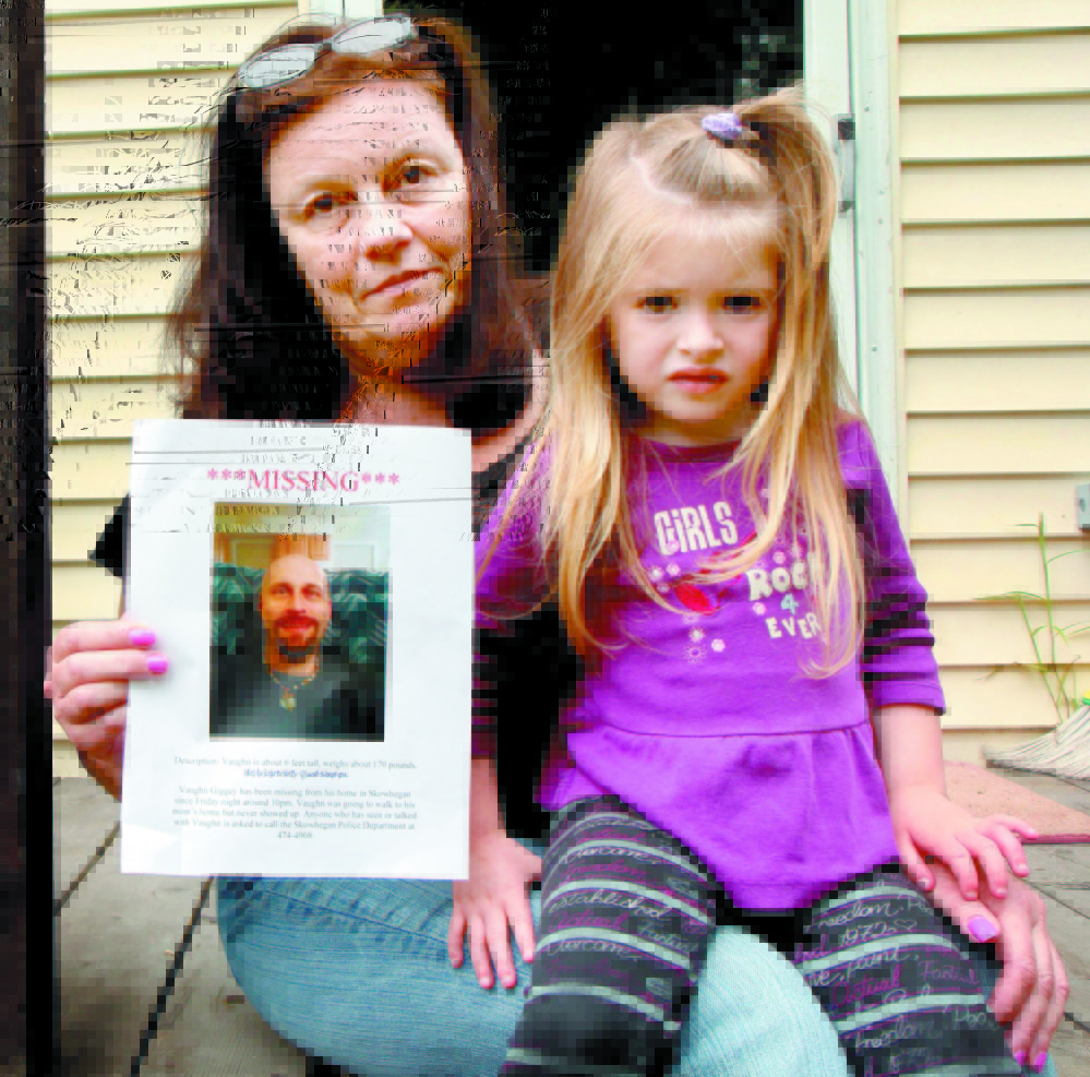 A MOTHER’S SORROW: Rosanne Dubay, mother of Vaughn Giggey, displays a photo of him after he disappeared in August while walking from his Skowhegan home to hers. With her is Giggey’s niece, Arrienna Bowring. His body was found later in Currier Brook about a quarter-mile from his home on Main Street.