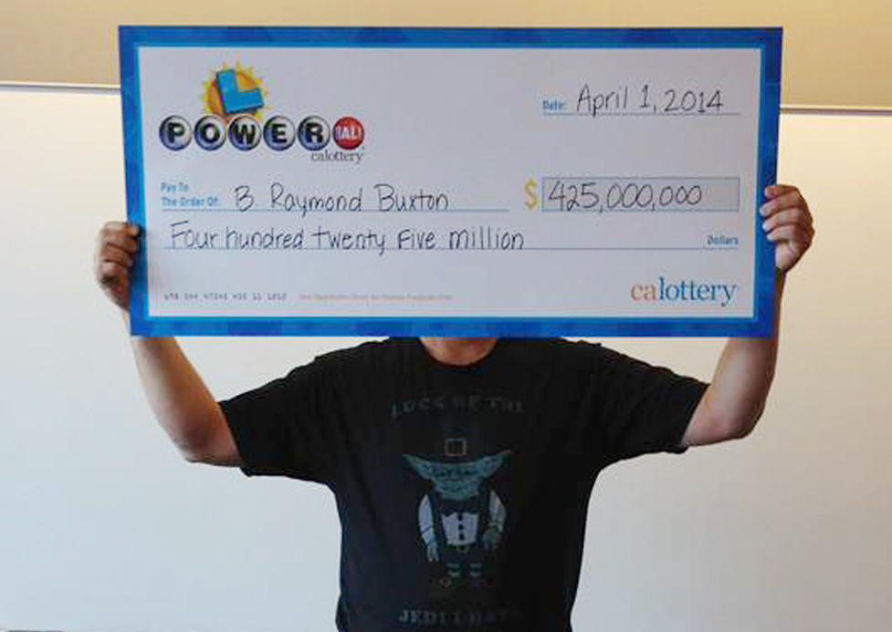 Powerball winner B. Raymond Buxton holds his $425 million check Tuesday in Sacramento, Calif. He is setting up a foundation focused on children’s health, hunger and education.