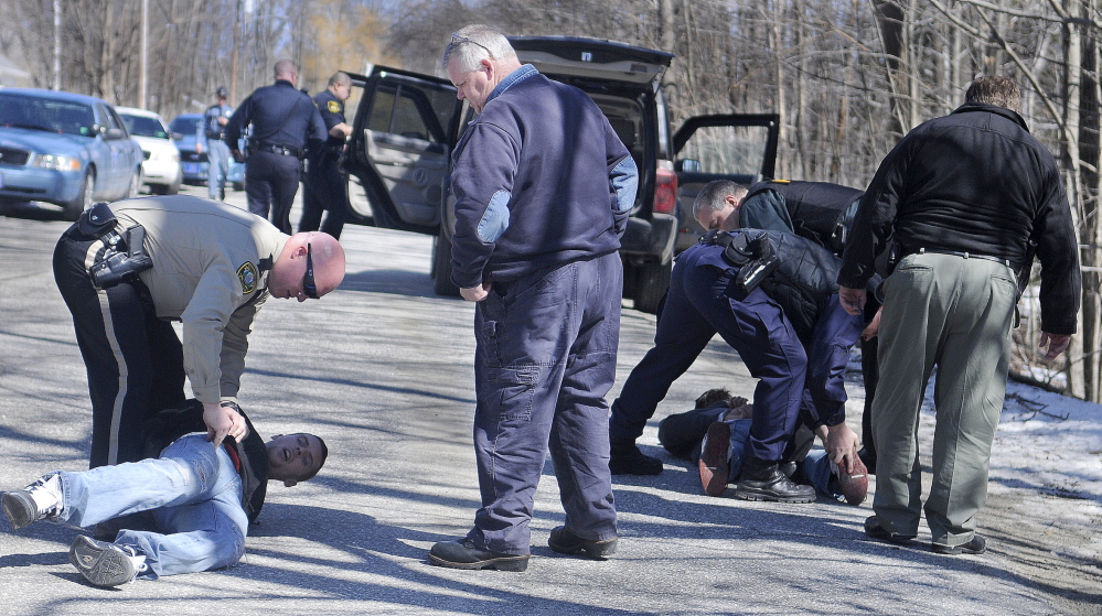 TWIN ARRESTS: Police handcuff and search two men Tuesday morning on Harrison Avenue in Gardiner.