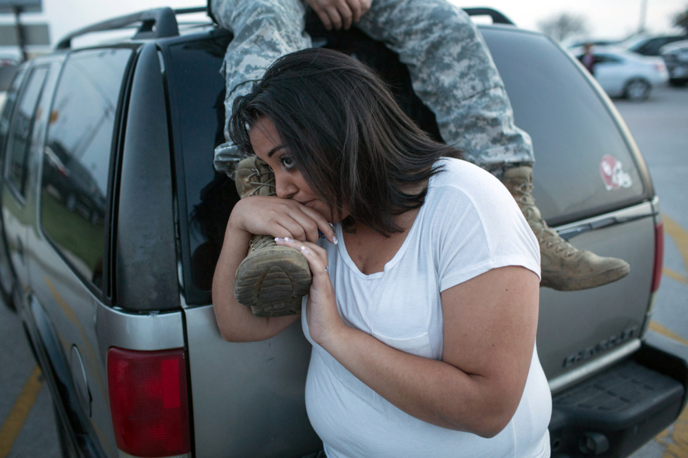 Lucy Hamlin and her husband, Spc. Timothy Hamlin wait for permission to re-enter the Fort Hood military base, where they live, following a shooting on base on Wednesday, April 2, 2014, in Fort Hood, Texas. One person was killed and 14 injured in the shooting, and officials at the base said the shooter is believed to be dead. The details about the number of people hurt came from two U.S. officials who spoke on condition of anonymity because they were not authorized to discuss the information by name.