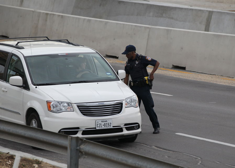 A police officer checks drivers’ IDs outside the main gate at Fort Hood, Texas, after a shooting at the Army base Wednesday, April 2, 2014. At least one person was killed and at least 14 injured in a shooting Wednesday at Fort Hood.