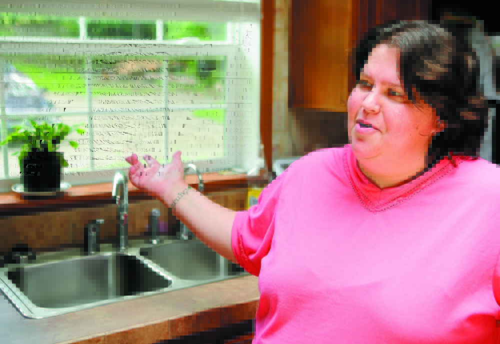 Staff file photo by Joe Phelan Wendy Brennan talks about the reverse osmosis arsenic filtration system in her Mount Vernon home in this 2011 file photo. When she learned about the arsenic concentrations, the family installed an $800 point-of-use filter under her kitchen sink.
