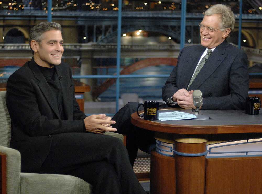 In this photo released by CBS, George Clooney, left, laughs with host David Letterman on the set of “The Late Show with David Letterman,” Tuesday, Nov. 28, 2006.