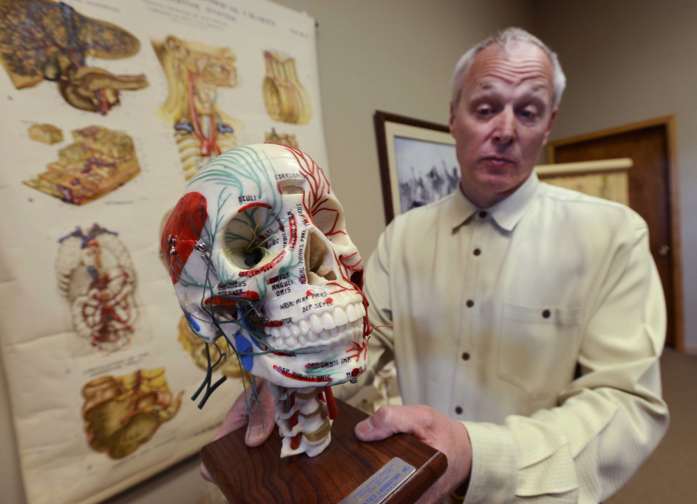 Dr. Tom Pliura holds an anatomical skull in his office in LeRoy, Ill. A cadaver lab sponsored by the McLean County Medical Society will be open to select students from advanced courses in subjects like anatomy and biology.