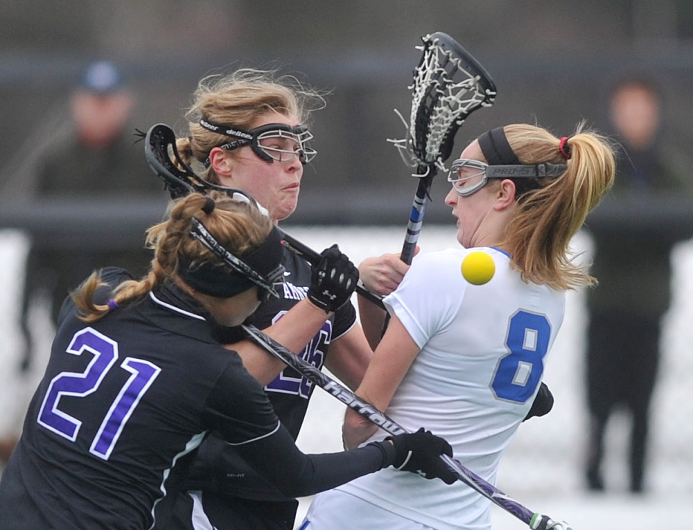 ROUGH LANDING: Colby College’s Emma Marjollet (8) collides with Amherst College’s Hanna Krueger (26) and Heath Cockrell in the first period at Colby College in Waterville on Saturday.