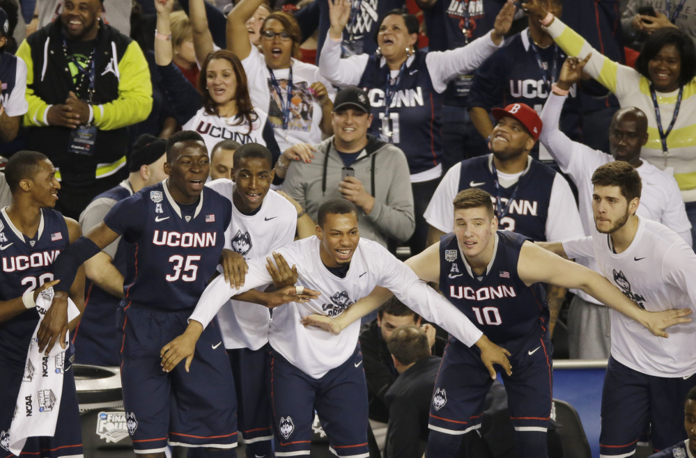 HAPPY DAYS: Connecticut players and fans begin to celebrate in the final moments of the team’s 63-53 victory over Florida on Saturday during the NCAA Final Four college basketball semifinal game in Arlington, Texas.