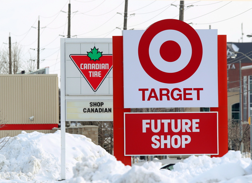 Snow is piled in the parking lot of the new Target store in Guelph, Ontario, as Canadian Tire posts a Canadian message on their sign. Canadian Tire, which operates nearly 500 stores in the country and stocks housewares, barbecue grills and other items besides tires, has increased its marketing and deepened its inventory of home decor to compete with Target.