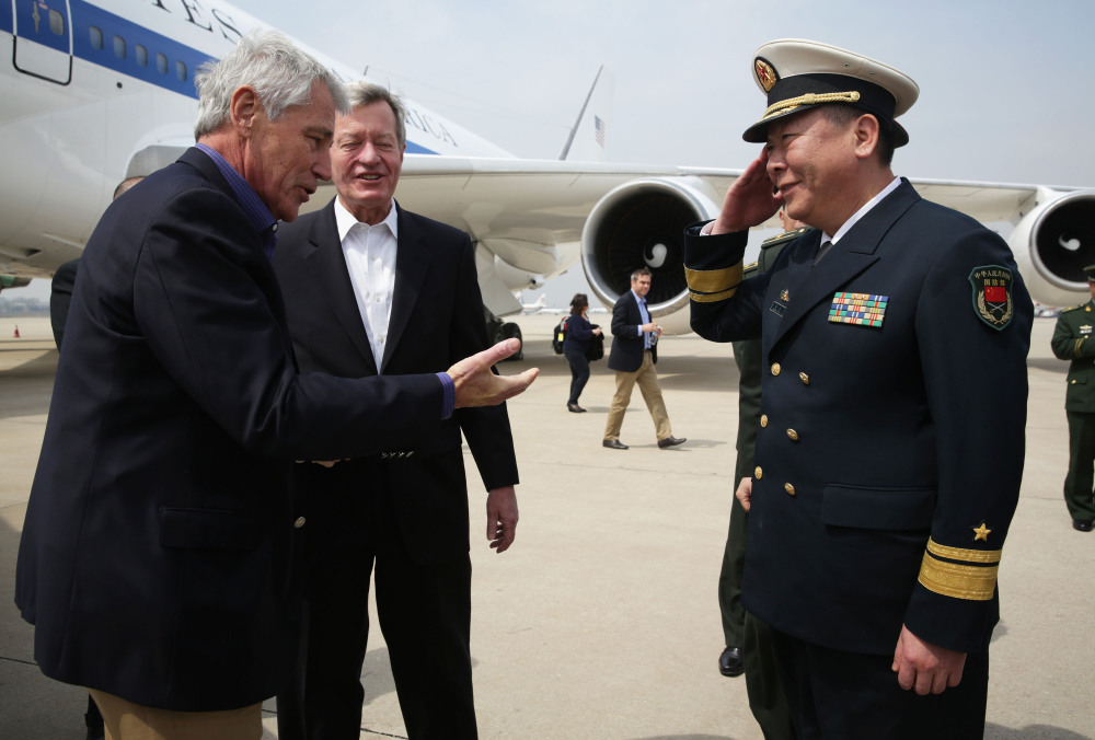 U.S. Secretary of Defense Chuck Hagel, left, is welcomed by Rear Admiral Guan Youfei, Director of Foreign Affairs Office of the Chinese Defense Ministry and U.S. Ambassador to China, Max Baucus, upon his arrival at Qingdao International Airport in Qingdao, China, on Monday.