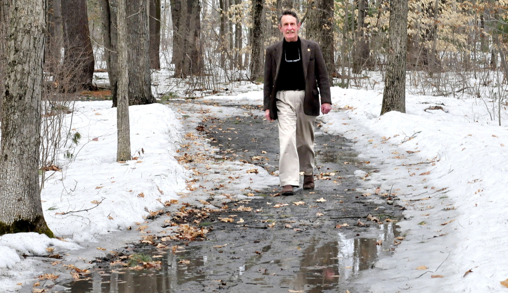 LONG TREK: Peter Garrett, president of Kennebec Messalonskee Trails, walks along the Winslow Community Trail on Monday. Garrett is retiring from the organization.