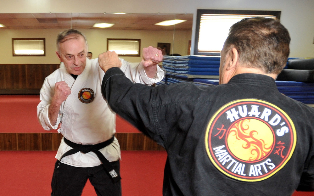Staff photo by Michael G. Seamans Ron Raymond, 65, spars with Randy Huard at Huard's Jujitsu and Karate Gym in Winslow on Saturday.