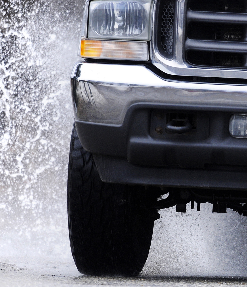 BAD ROAD: A truck hits a pothole Monday in Hallowell. Roads across Maine are bumpy from a long winter.