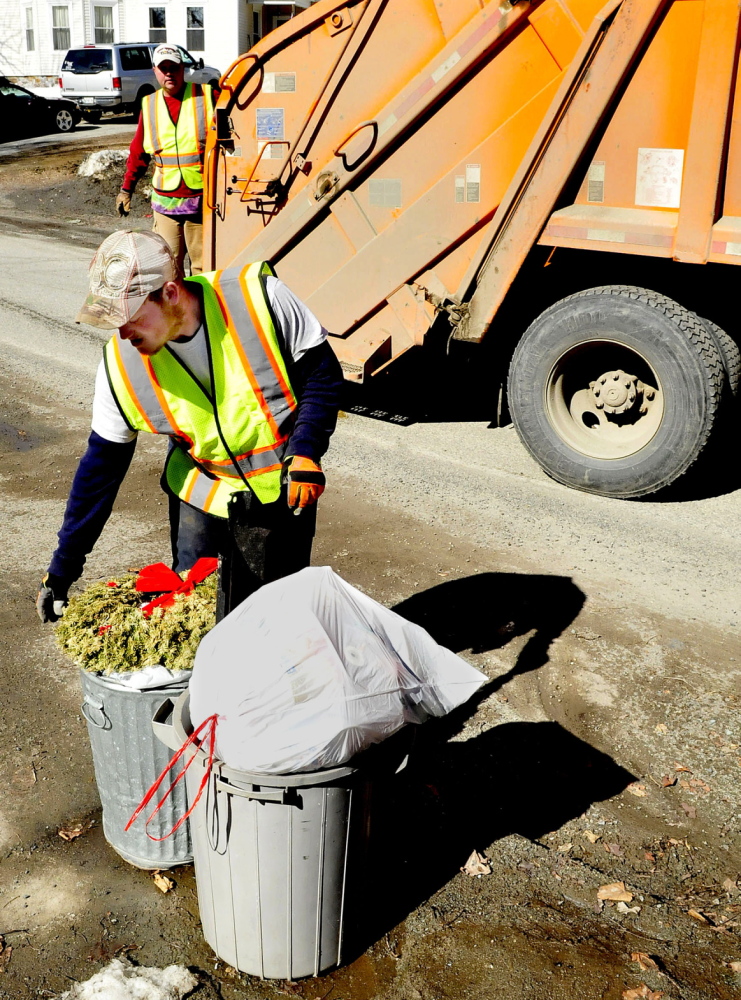 WASTE NOT: Waterville Public Works Department employees Larry Colson, front, and Brian Ames pick up trash on April 2. The city is considering alternatives to solid waste collection.