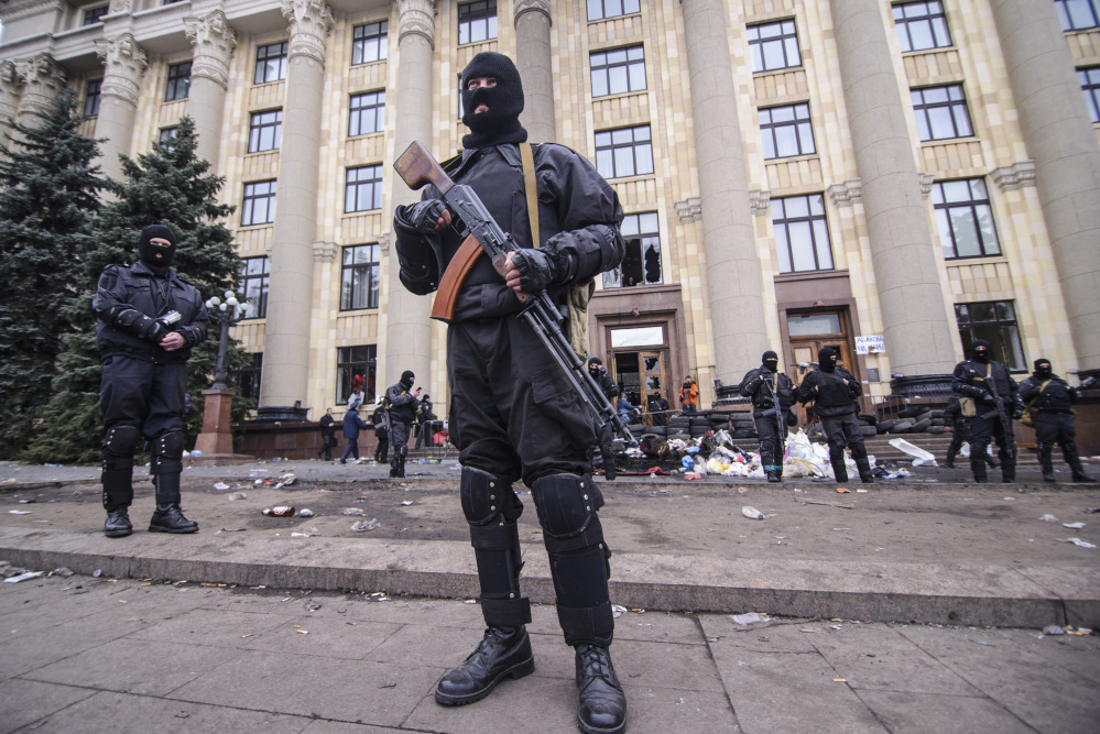 Members of a Special police unit guard the regional administration building in Kharkiv, Ukraine, Tuesday.