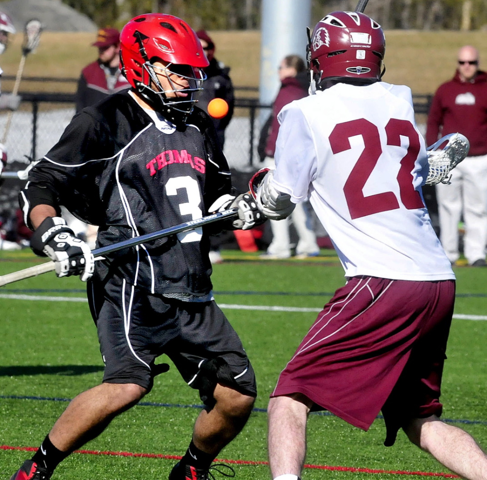 Staff photo by David Leaming Thomas College lacrosse player Sheldon Jones, left, and University of Maine in Farmington’s Michael Keim go after loose ball at Thomas College in Waterville on Wednesday, April 9, 2014.