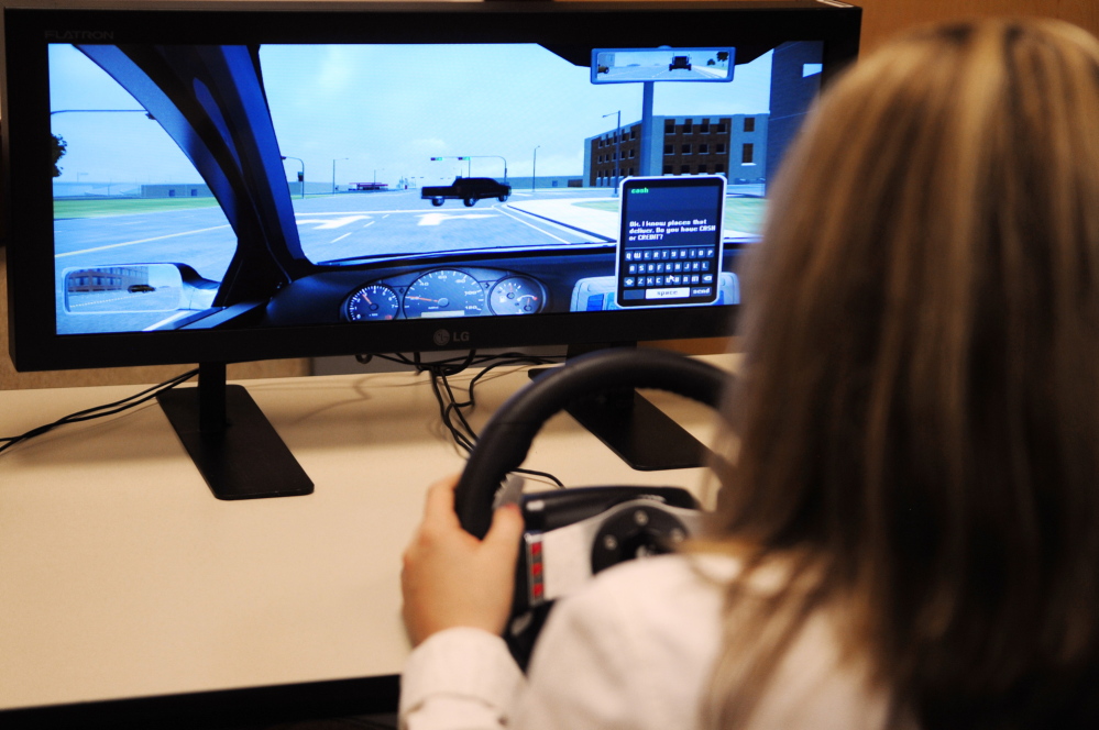 distracted driving test: Winthrop High School freshman Kayleigh Oberg demonstrates a driving simulator after a news conference about distracted driving on Thursday in Augusta.